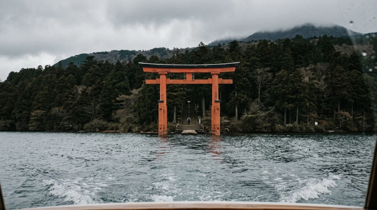 Red torii of Hakone Shrine standing in the water seen from the deck on a Lake Ashi cruise, Hakone, Japan